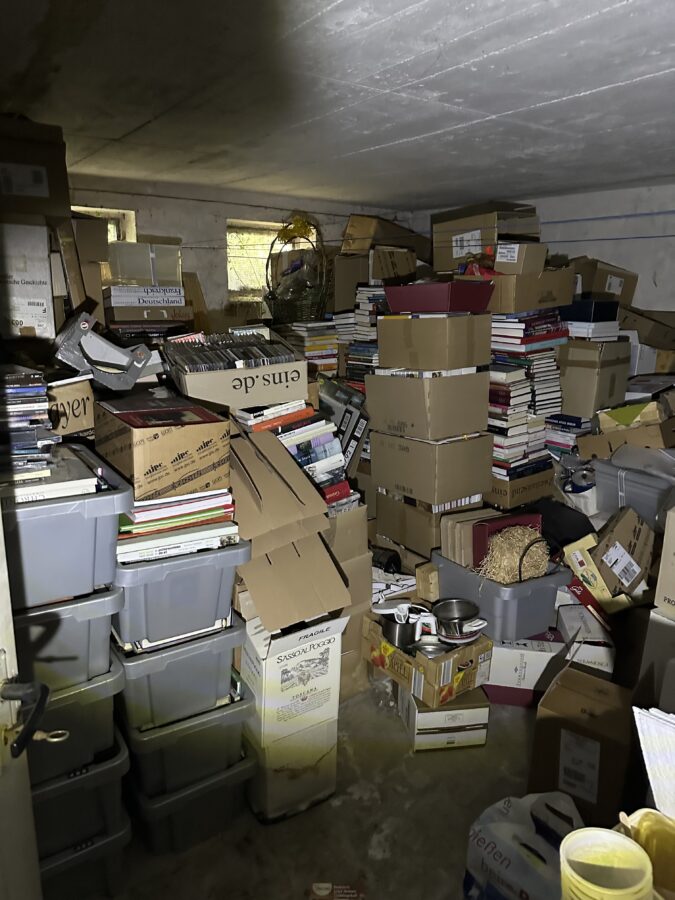 Vollgestellter Keller mit Bücherkisten und Kartons